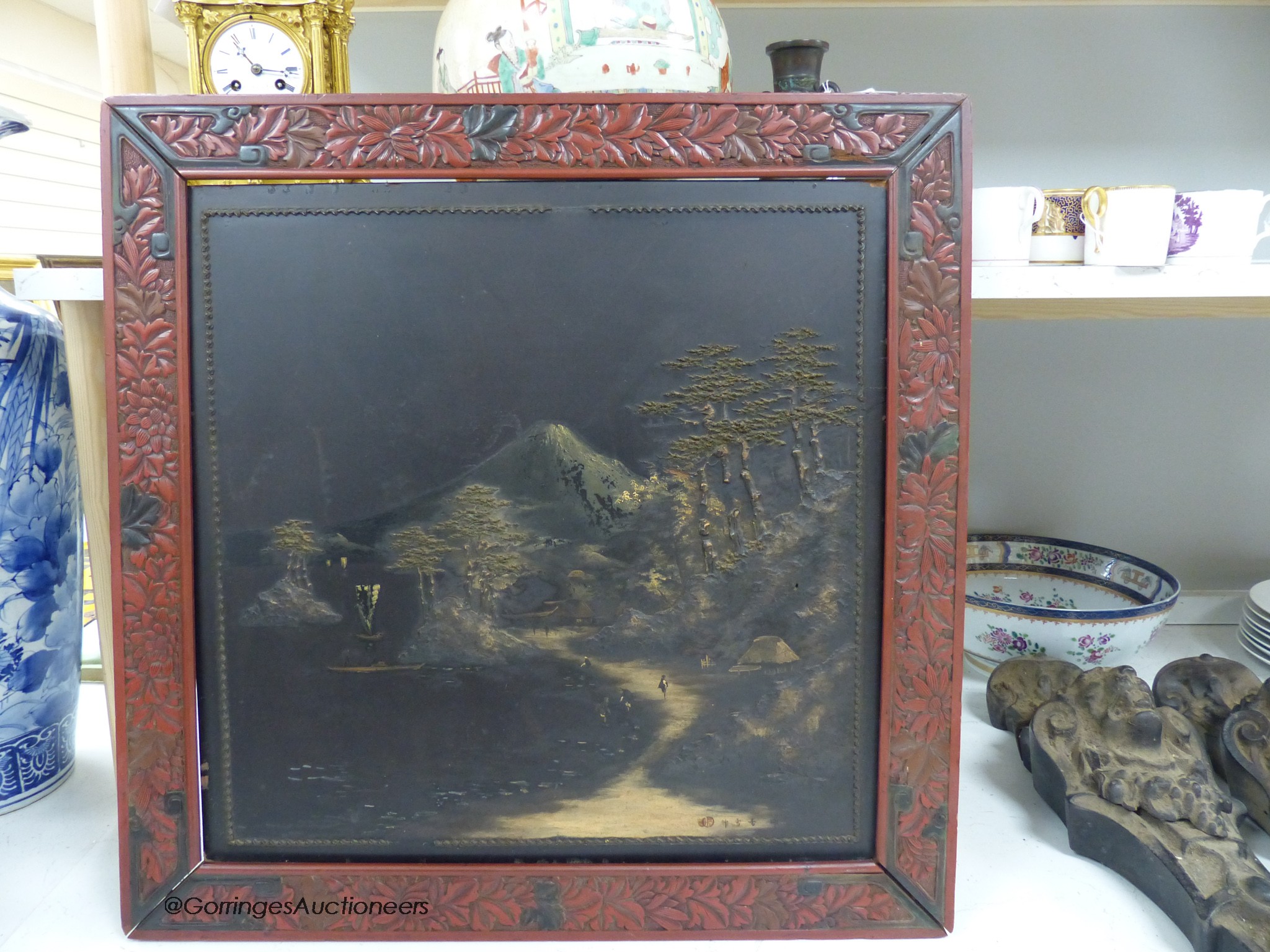 A Japanese lacquer landscape panel, in red lacquered frame, 59 x 59cm